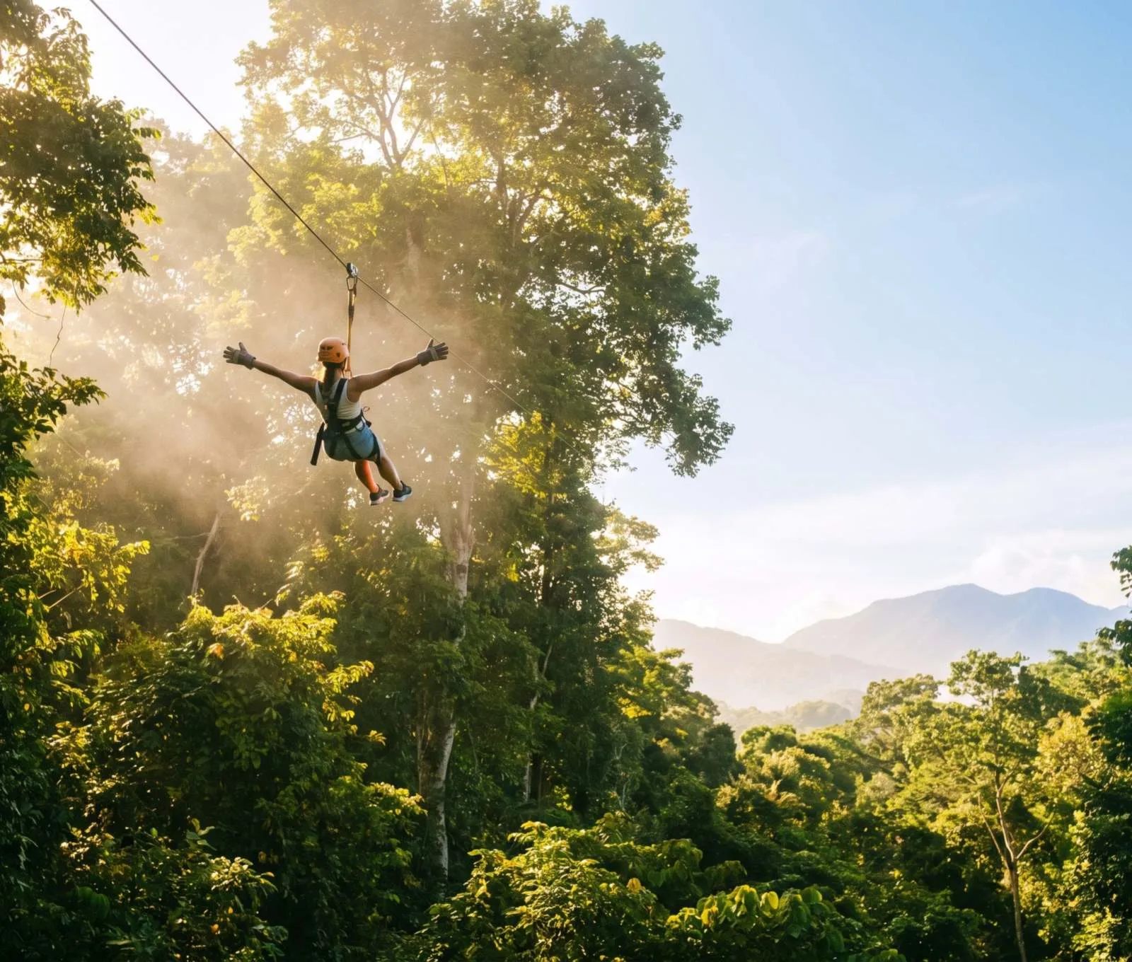 A rider on a zip-line above rainforest canopy